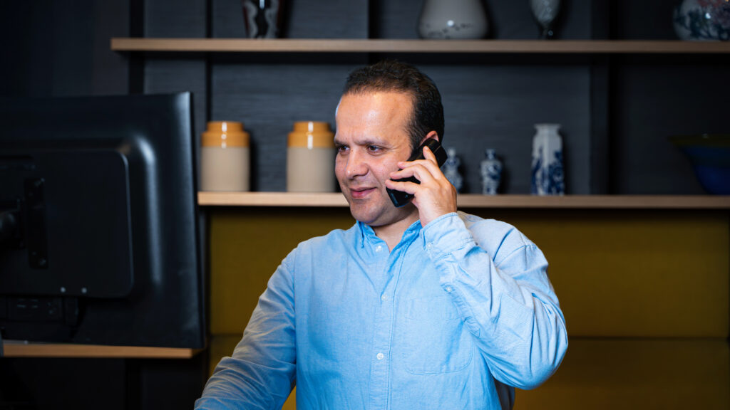 Nachtreceptionist die belt met bezoekers terwijl hij professionele nacht receptie services verleent voor veilige hotelservice en 24/7 gastbeleving.