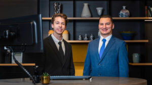 Twee medewerkers van Nacht Receptie Services achter de hotelreceptie